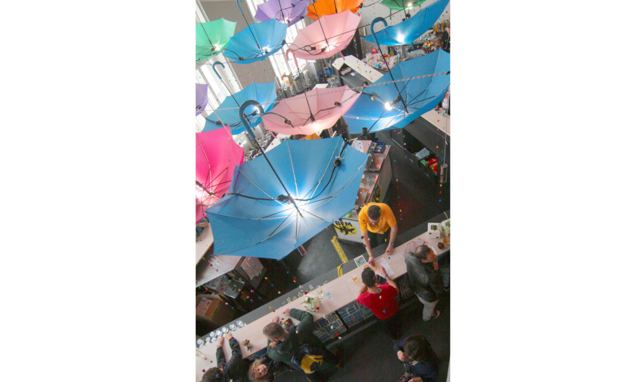 Quinzième édition, 2024. De la couleur dans la Maison du Peuple. Les parapluies retournés accueillent des lampes et ont des figurines en bois accrochées. (photo Ludesco)