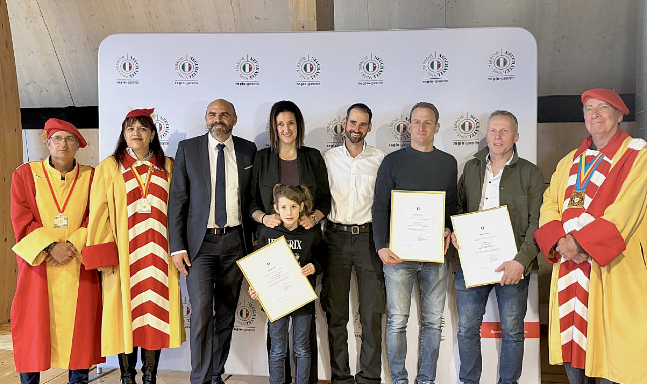 Le conseiller d'État Laurent Favre et les Vignolants aux côtés des 3 producteurs distingués : de gauche à droite, Manuela Sauser et Sébastien Maurer de la fromagerie de La Sagne, Alexandre Perrochet du domaine la Maison carrée à Auvernier et Claude-Alain Christen de la boucherie Christen Delicatessen à La Chaux-de-Fonds (Photo EM)