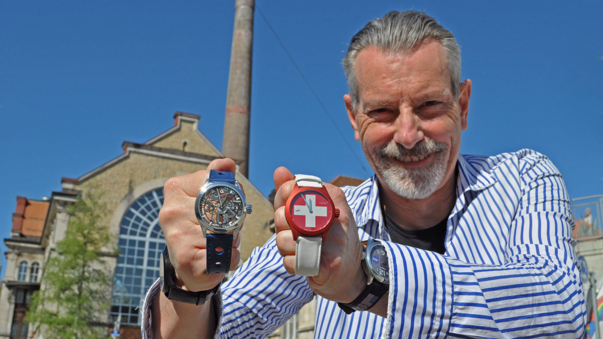 Alain Schneider pose avec les deux montres préférées de sa gamme devant l’usine eléctrique. (gs)