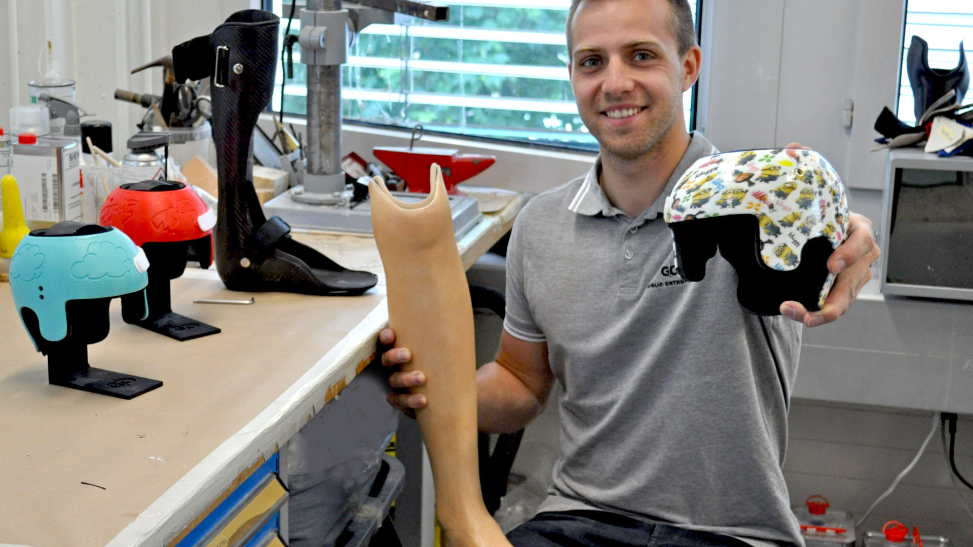 Steven Recordon avec une partie de la panoplie du maître orthopédiste: casques pour bébés, orthèses, prothèse, etc. (photo Le Ô).